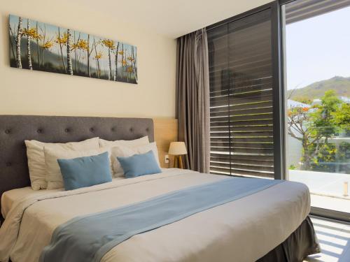 a bedroom with a large bed and a large window at LyGia Villa Long Hải in Long Hai