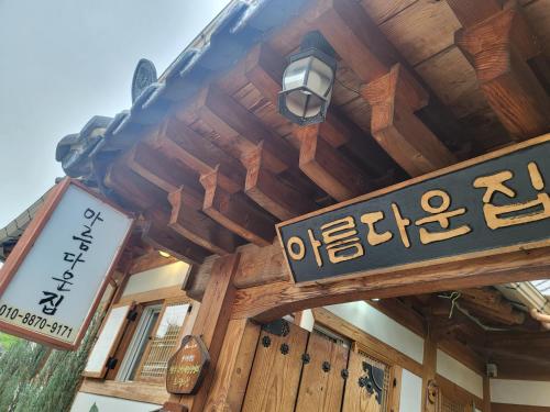 een houten gebouw met een straatbord erop bij Beautiful House in Jeonju