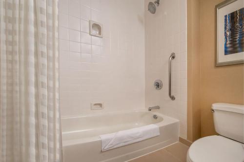 a bathroom with a white tub and a toilet at Gaithersburg Marriott Washingtonian Center in Gaithersburg