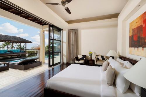 a bedroom with a large bed and a patio at Villa Jamalu by Nakula in Jimbaran