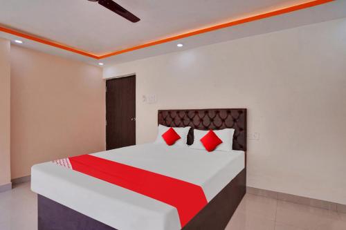 a bedroom with a large bed with red pillows at Super OYO Flagship Hotel Relax Rainbow in Gulzārbāgh