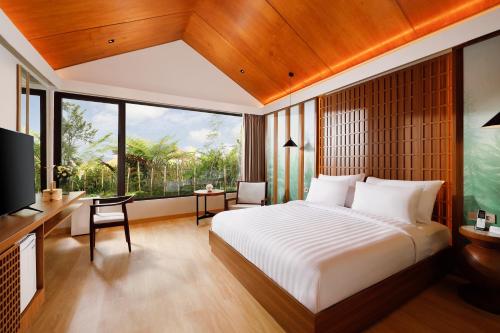 a bedroom with a large bed and a large window at Dusun Bedugul Asri in Bedugul