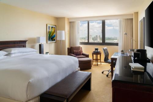 Habitación de hotel con cama, silla y escritorio. en Miami Marriott Dadeland en Miami