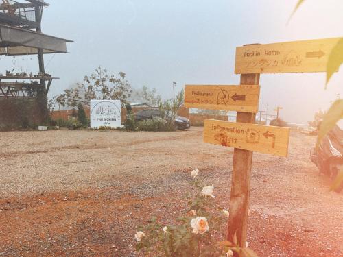 a wooden sign in the middle of a field at Phu Morinn Cafe &Camping Monjam in Mon Jam