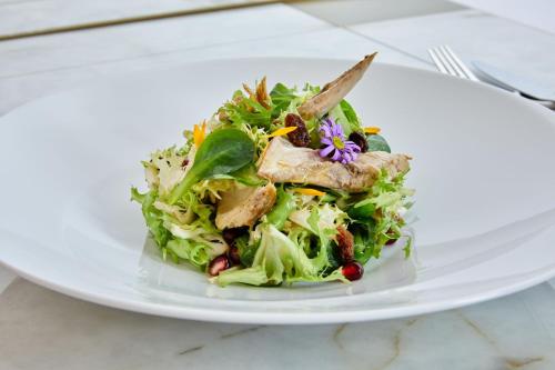 a white plate with a salad on a table at JW Marriott Hotel Madrid in Madrid
