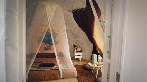 a bedroom with a bed with a net at Phu Morinn Cafe &Camping Monjam in Mon Jam