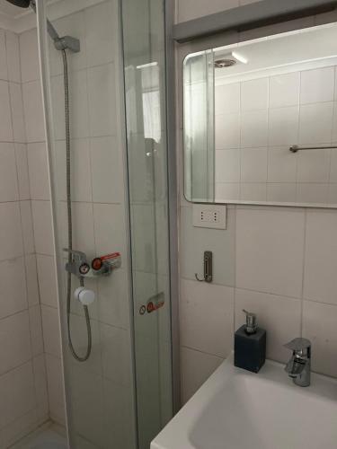La salle de bains est pourvue d'une douche, d'un lavabo et d'un miroir. dans l'établissement Departamento MBlanc, Ski El Colorado,, Salida a Canchas, Piscina, à Santiago