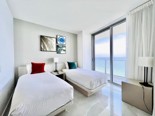 two beds in a bedroom with a view of the ocean at Dramatic Ocean View at Hyde Resort And Residences in Hollywood