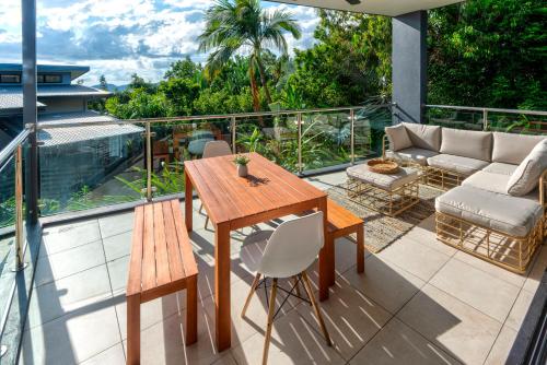 a patio with a wooden table and chairs on a balcony at Pinnacle Apartments on Hamilton Island by HIHA in Hamilton Island
