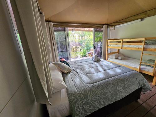 a small bedroom with a bed and a window at Castaways Moreton Island in Bulwer