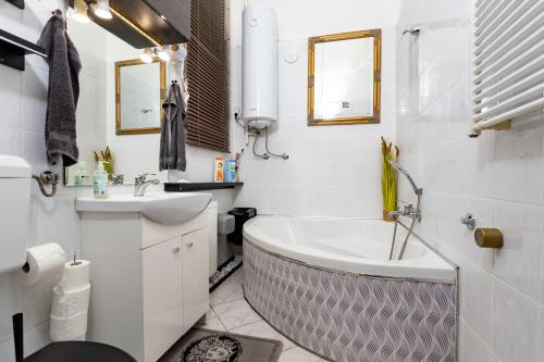 a bathroom with a tub and a sink at Home City Center Terrace Apartment in Budapest