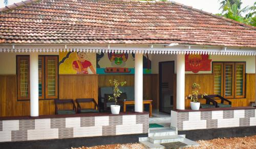 a small house with a thatched roof at Vrindavan homestay in Munroe Island