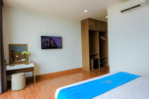 a bedroom with a bed and a desk and a mirror at Havana Con Dao Hotel in Con Dao