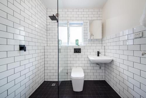 a white bathroom with a toilet and a sink at Opposite Park - Nearby Beach in Melbourne