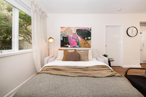 a bedroom with a large bed with a large window at Opposite Park - Nearby Beach in Melbourne