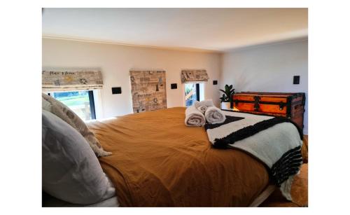 ein Schlafzimmer mit einem großen Bett mit Handtüchern darauf in der Unterkunft Adventurer's Chest - Taiwawe in Hotwater Beach