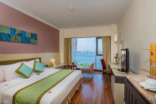 ドンホイにあるSai Gon Quang Binh Hotelのベッド付きのホテルルームで、海の景色を望めます。