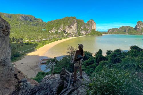 a woman standing on a cliff overlooking a beach at Tinidee Hideaway Tonsai Beach Krabi - SHA Extra Plus in Tonsai Beach