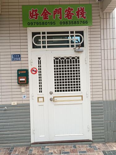 una puerta blanca con una señal encima de ella en un edificio en 好金門民宿 en Jincheng