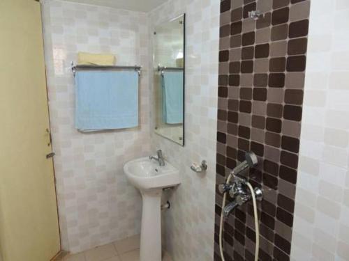 a bathroom with a sink and a mirror at John's Highland Comfort (Guest House) in Majorda
