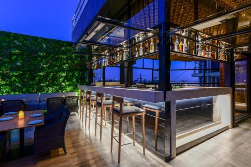 a bar with chairs and tables in a restaurant at Regenta Place Raysons Kolhapur in Kolhapur