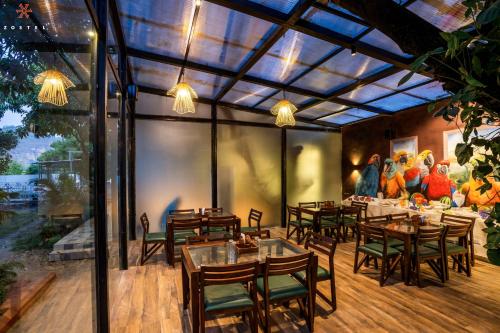 een restaurant met tafels en stoelen en een schilderij van kippen bij Zostel Jim Corbett in Rāmnagar