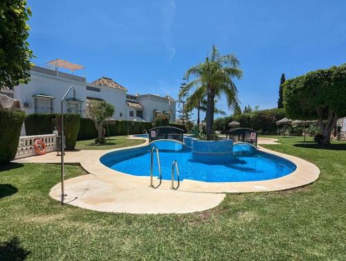 een zwembad in een tuin naast een huis bij Apartamento los Cocoteros in Santa Fe de los Boliches