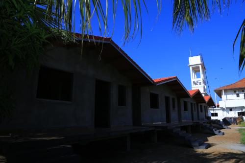 a building with a clock tower in the background at PJ Hotels Jaffna in Jaffna