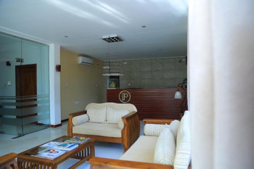 a living room with two chairs and a coffee table at PJ Hotels Jaffna in Jaffna