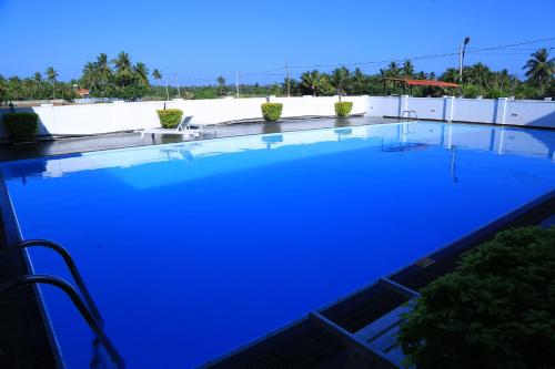 a large swimming pool with blue lighting on a roof at PJ Hotels Jaffna in Jaffna