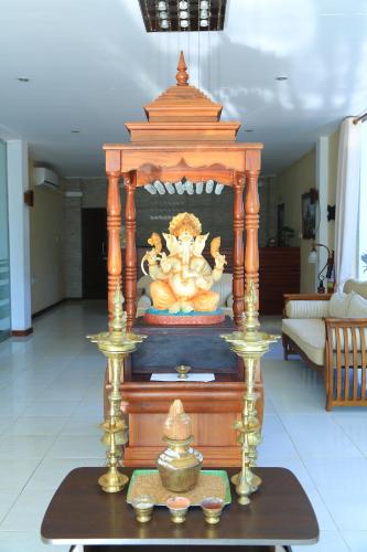 a wooden altar with a statue in the middle of a room at PJ Hotels Jaffna in Jaffna