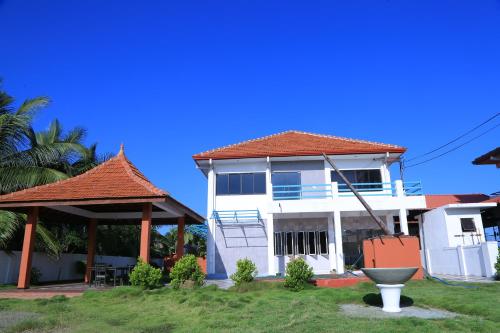 a white house with a gazebo at PJ Hotels Jaffna in Jaffna