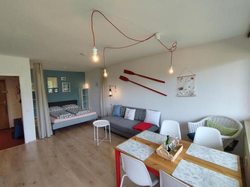 ein Wohnzimmer mit einem Sofa und einem Tisch in der Unterkunft MOOKI Beach Apartment in Bodensdorf