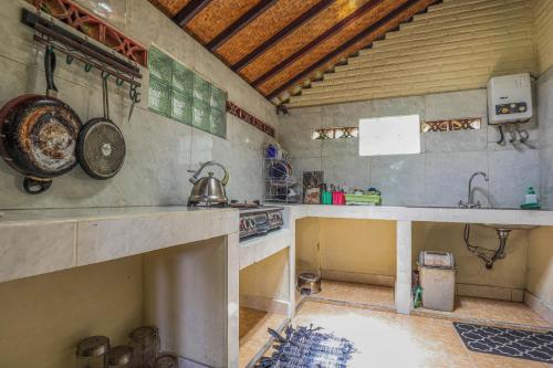 a kitchen with a counter and a sink and a stove at Sari Bamboo Bungalows in Ubud