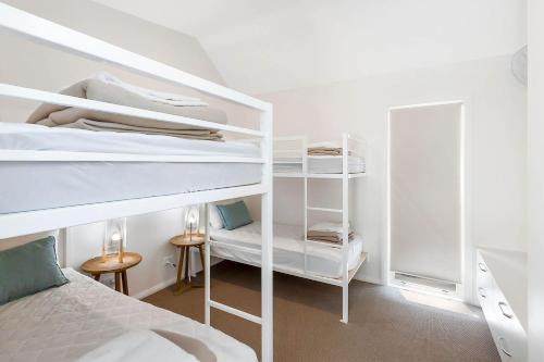 a bedroom with two bunk beds and a bed at Reflections Bermagui - Holiday Park in Bermagui