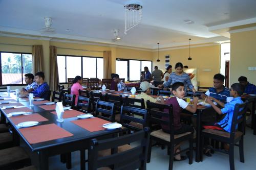 a group of children sitting at tables in a restaurant at PJ Hotels Jaffna in Jaffna
