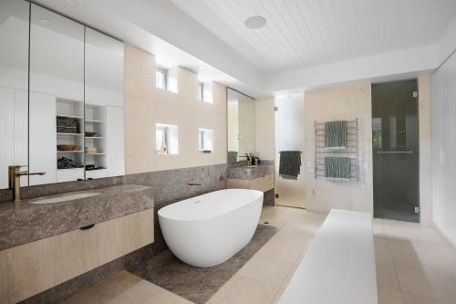 a large bathroom with a large tub and a sink at 12 Noosa Parade, Noosa Heads in Noosa Heads