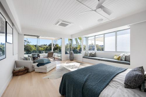 a bedroom with a bed and a living room with windows at 12 Noosa Parade, Noosa Heads in Noosa Heads