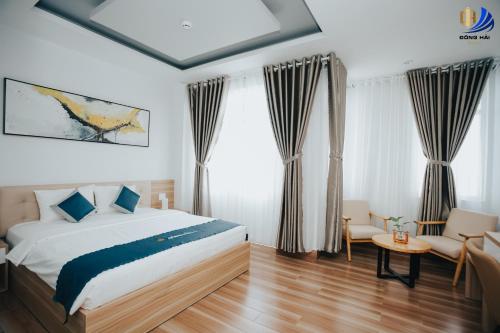 1 dormitorio con cama, cortinas y mesa en Dong Hai Hotel _ Rach Gia, en Rạch Giá