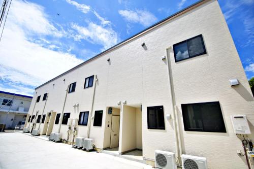 un gran edificio blanco con ventanas laterales en クラリス Ⅱ RoomE, en Ishigaki Island