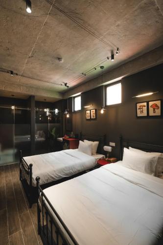two large beds in a room with two windows at The Chum Boutique in Hue