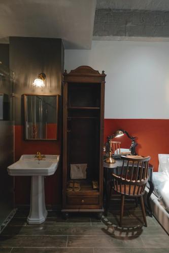 a bathroom with a sink and a mirror and a bed at The Chum Boutique in Hue