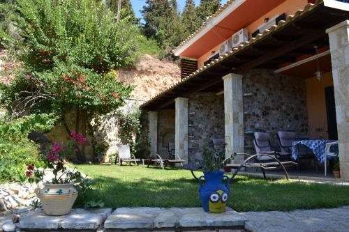 a house with a yard with two vases in the grass at Edem Studios in Sivota