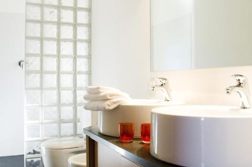 a white bathroom with two sinks and a toilet at Tenuta Madonnina in Castiglione di Sicilia