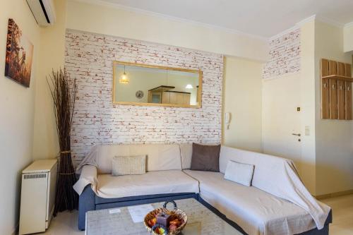 a living room with a couch and a brick wall at Gemico by GuestCorfu in Corfu