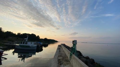 un barco está atracado en un muelle en un lago en Aspö Glamping en Drottningskär