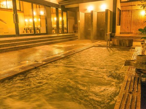 une piscine d'eau au milieu d'un bâtiment dans l'établissement Yuzanso, à Ōtsu