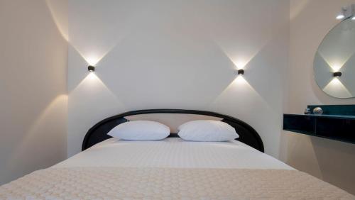 a bedroom with a bed with two white pillows at Velky Sen Luxury Apartments in Sarti