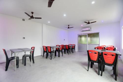 a room with tables and chairs and red chairs at Hotel O Mango Leaf Hotel & Restaurant in Baharampur