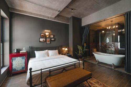 a bedroom with a bed and a bathtub and a bath tub at The Chum Boutique in Hue